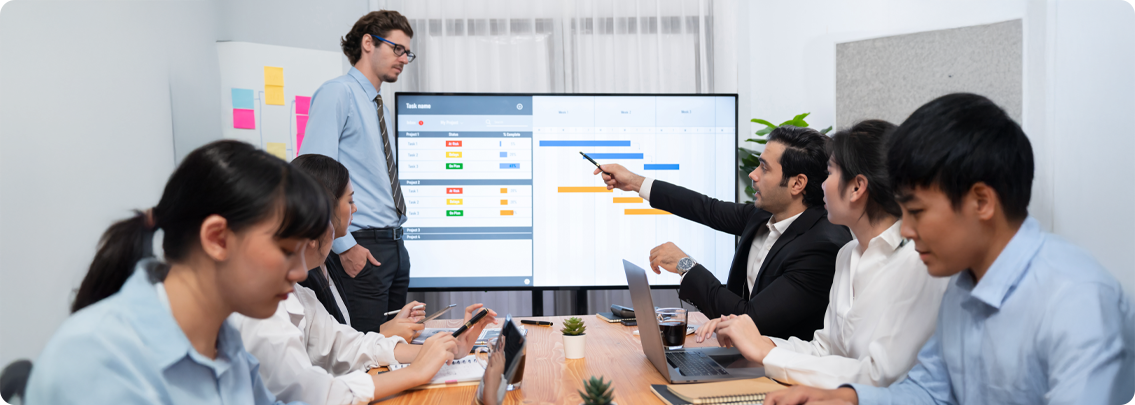 Team collaborating around a laptop displaying a productivity dashboard, representing unified business management.